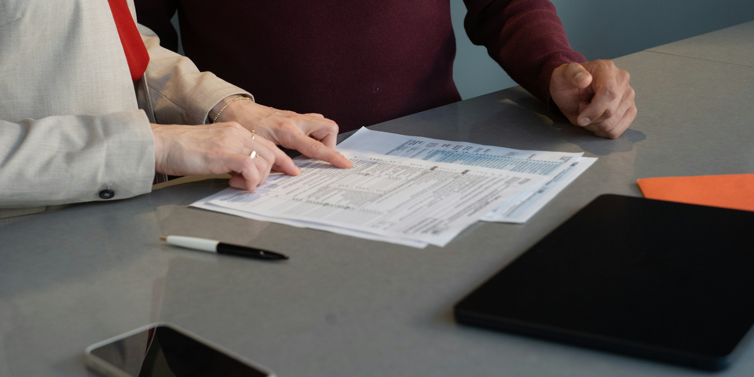 Deux dirigeants examinant un dossier de part et d'autre d'une table